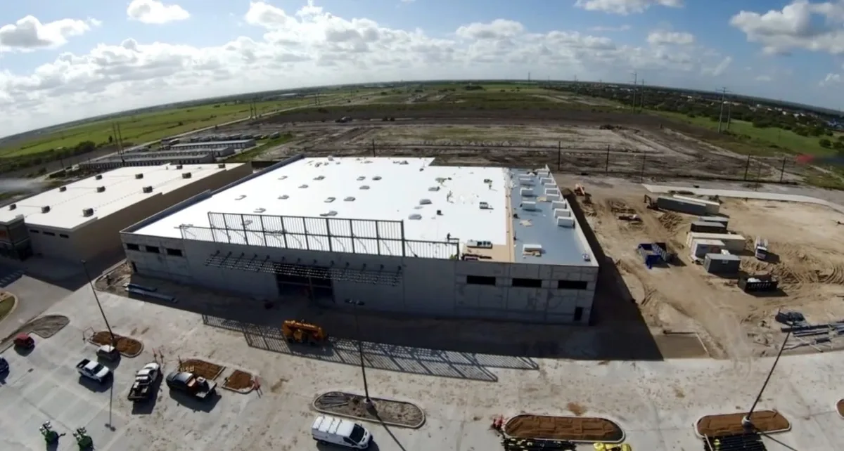 Aerial view of a new white commercial roof on a large retail building in South Texas